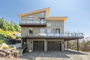 Enjoy a home with a spacious garage, covered outdoor area, and balcony overlooking natural surroundings.