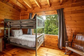 A wooden cabin room with a bunk bed, a bench, and a window with curtains. - NEW Dog House, A+ Location, Hot Tub, Mini Golf, Views, Fire Pit, Arcade (Sevierville)