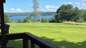 A grassy deck with a view of a lake and trees. - Lakeside Loft (Direct Access to Moosehead Lake!) (Greenville)