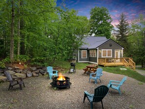 A cabin with a fire pit, outdoor seating, and a deck.