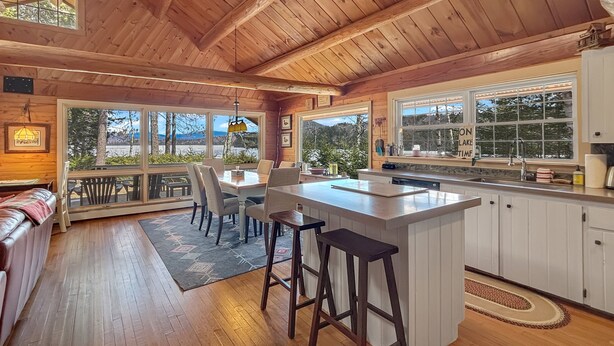 L’intérieur d’une cabane en bois comprend un coin repas, une cuisine et de grandes fenêtres.