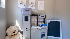 A kitchen with a microwave, toaster, and kettle. There are three framed signs on the wall. - Cozy Munds Park Cabin ~ Fire Pit & Sunset Views (Munds Park)
