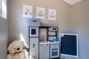 Una cucina con forno a microonde, tostapane e bollitore. Sono presenti tre quadri appesi al muro.