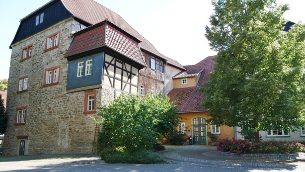 A traditional European building with a stone facade, multiple windows, and a cobblestone courtyard. - Schloss Goldacker - das Schloss der Gesundheit (Unstrut-Hainich)