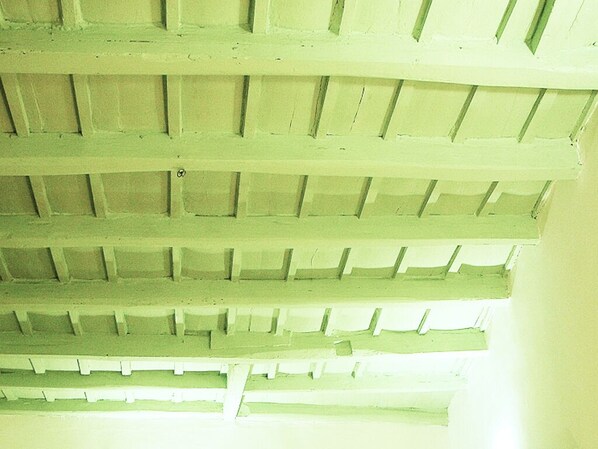 A ceiling with a grid pattern of wooden beams.