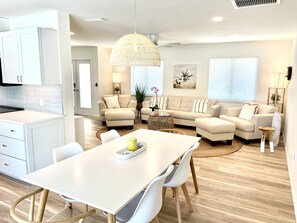 En moderne stue med sofa, sofabord og spiseplads.