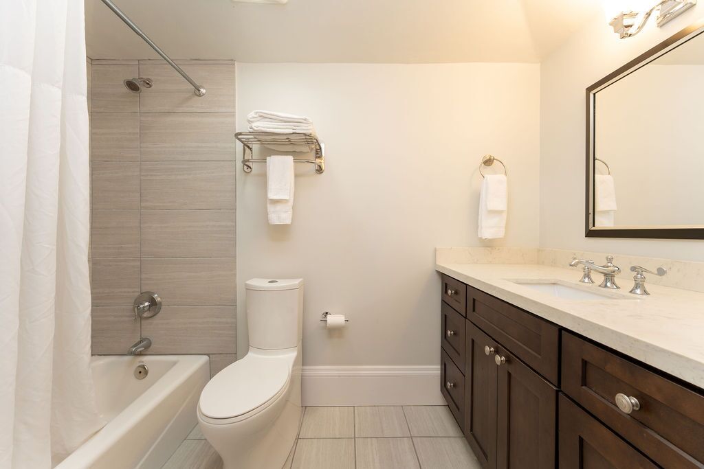 A modern bathroom with a bathtub, toilet, and sink.