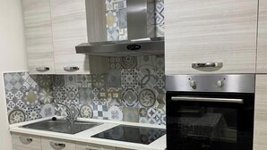 A modern kitchen with a double sink, stainless steel appliances, and patterned backsplash tiles. - Studio nearby Hospital and Train railway. (Livorno)