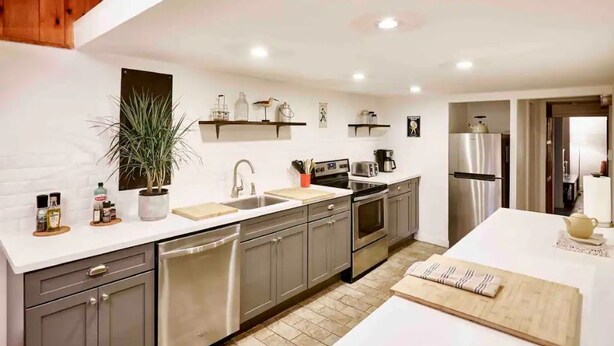 A modern kitchen with grey cabinets, stainless steel appliances, and a white countertop. - Never Lonesome Hunter: Smart 4bd Getaway near Mtn (Hunter)