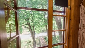 A wooden interior with a large sliding glass door leading to a garden with potted plants. - BW Boutique Hotel (Central Lake)