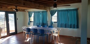 Ein Essbereich mit einem für sechs Personen gedeckten Tisch, blauen Stühlen und blauen Vorhängen.