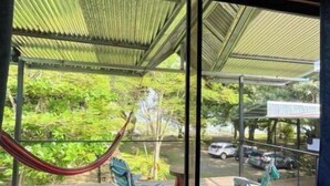 A view from a room with a large window overlooking a covered outdoor area with chairs and a hammock. - Terrazas del Golfo Oceanfront, Room Manigordo! Pet Friendly! (Provincia de Puntarenas)