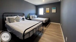 Quarto com duas camas, uma janela e um ar condicionado.