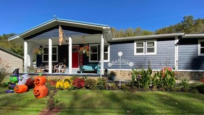 Una casa con porche, una bandera y decoraciones de Halloween.