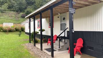 A single-story building with a porch, a staircase, and a sign indicating it is the 'Intimidator House.'