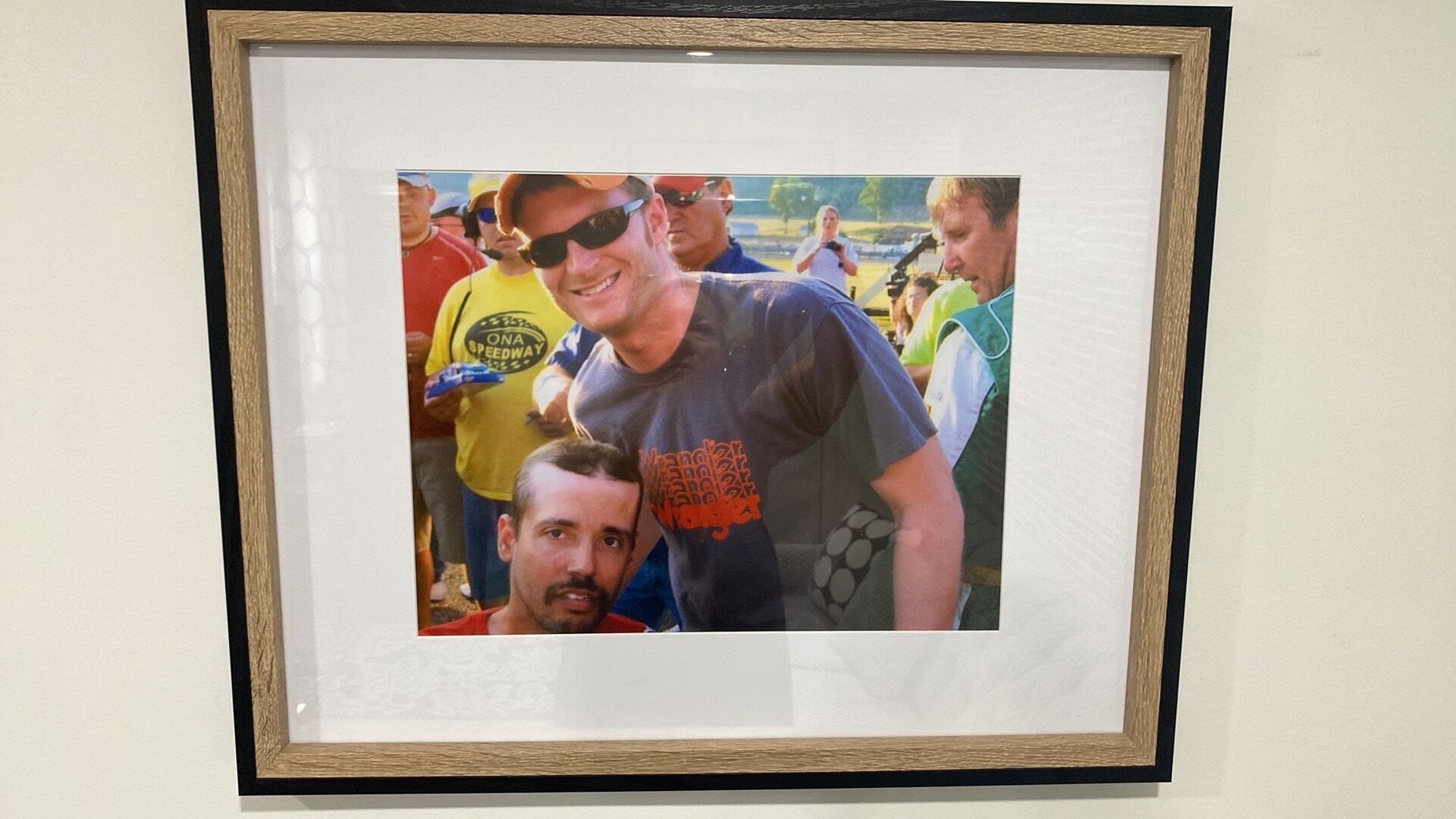 Ett inramat fotografi som föreställer en grupp människor vid ett evenemang.