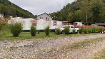 A mobile home with a gravel driveway and a truck parked in front.
