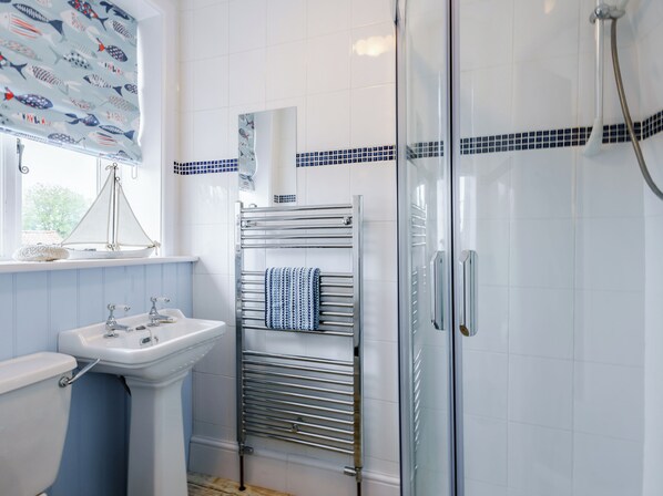 A bathroom with a sink, mirror, towel rack, shower, and a window with a view. - 3 bedroom accommodation in Holt (Holt)