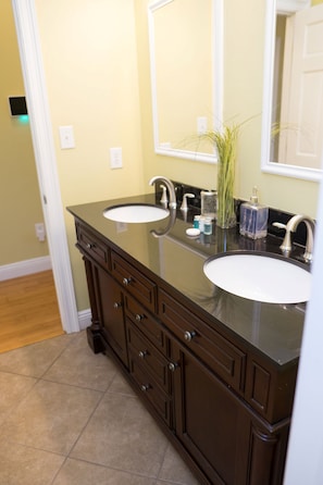 A bathroom with two sinks, a mirror, and a cabinet.