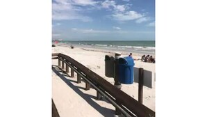 A beach with a wooden walkway, trash bins, and a clear sky. - Beach Property with get away feeling. (Fort Myers Beach)