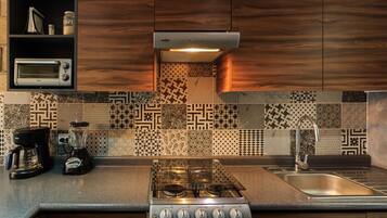 A modern kitchen with a gas stove, a coffee maker, a blender, and a toaster.