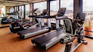 Ein Fitnessraum mit Laufbändern, Crosstrainern und Rudergeräten.