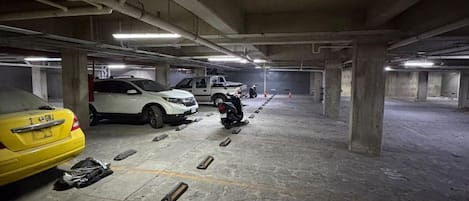 Een meerlaags parkeergarage met betonnen pilaren en verlichting.