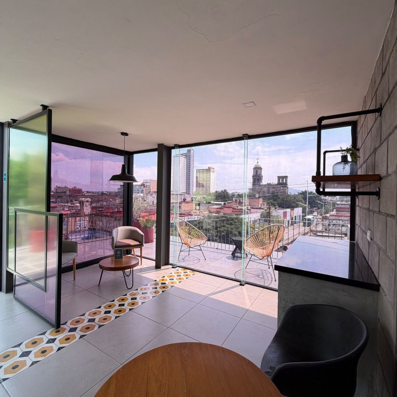 A modern interior with a large glass window, a wooden table, and two chairs.