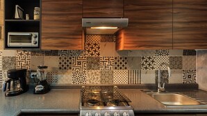 Una cocina moderna con estufa a gas, cafetera, licuadora y tostadora.