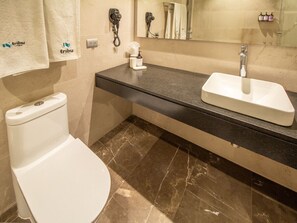 A bathroom with a toilet, a sink, a mirror, and a towel rack. - Deluxe Suite w/Incredible View & Pool | 1 BD | Tribu Sonata (Guadalajara)
