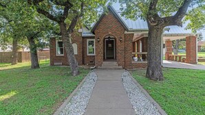 A brick building with a gabled roof, a front entrance, and a covered porch area. - Charming, Tudor Style Home Newly Renovated! (Mineral Wells)