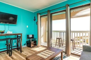 Relax in this inviting space with a flat-screen TV, comfortable sofa, and a wooden table with a bench.