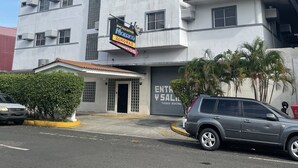 Un edificio de varios pisos con un letrero que anuncia servicio las 24 horas.