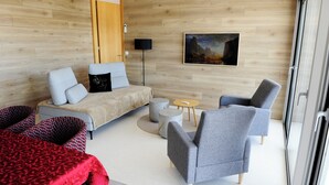 A modern room with a sofa, armchairs, a small round table, and a painting on the wall. - Casa da Montanha_Grupo Casas Vale do Lima (Arcos de Valdevez)