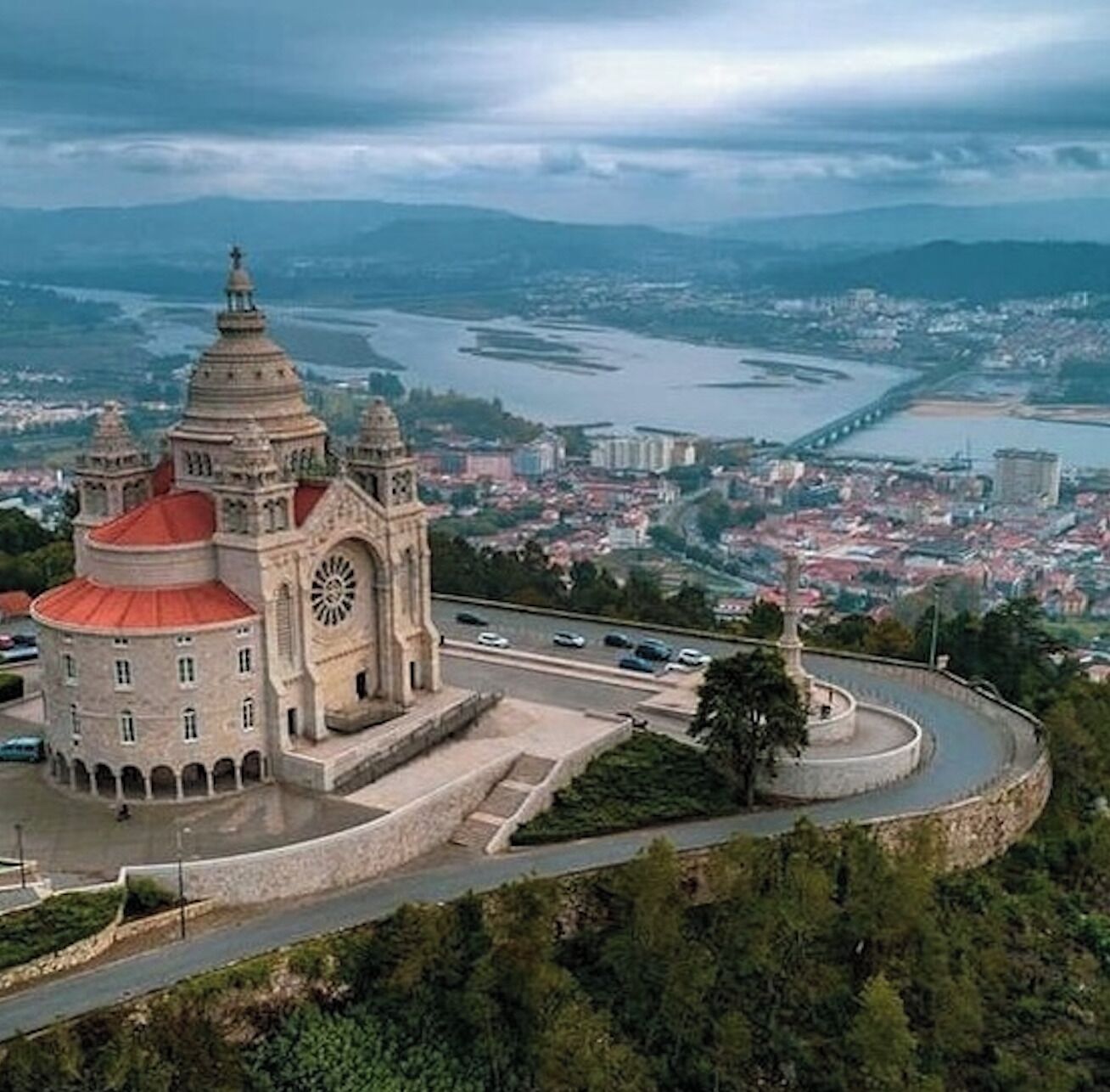 Un edificio histórico con una torre de reloj, una glorieta y vistas de un río y el horizonte urbano.