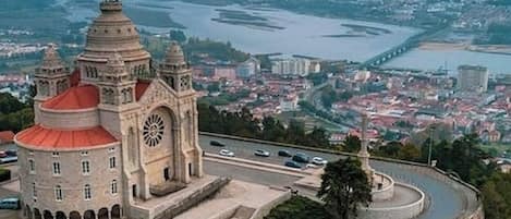 Un edificio histórico con una torre de reloj, una glorieta y vistas de un río y el horizonte urbano.