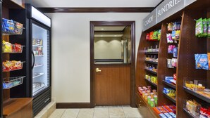 A corridor with a refrigerated snack display on the left and a candy and sundries shelf on the right.