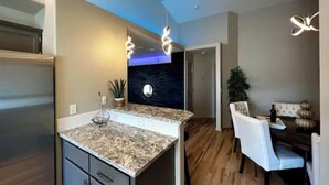 A modern kitchen with granite countertops, a built-in oven, and a dark backsplash. - Luxury 3BR Home, Comfy 🛌, WiFi, Quiet, Near (Boise)