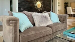 A modern living room with a grey sofa, two light blue pillows, and a fluffy grey throw. - Luxury 3BR Home, Comfy 🛌, WiFi, Quiet, Near (Boise)