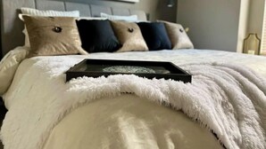 A neatly made bed with a fluffy white blanket, a black tray, and a patterned pillow. - Luxury 3BR Home, Comfy 🛌, WiFi, Quiet, Near (Boise)