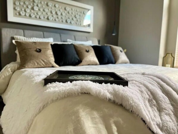 A neatly made bed with a fluffy white blanket, a black tray, and a patterned pillow. - Luxury 3BR Home, Comfy 🛌, WiFi, Quiet, Near (Boise)