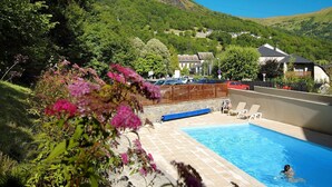 Une piscine avec vue sur une montagne et des maisons en arrière-plan.