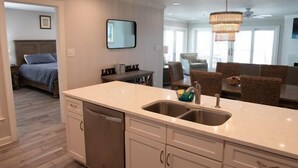 Una cocina moderna con lavavajillas, pileta doble y muebles de madera.