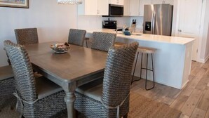 Una cocina moderna con armarios blancos, electrodomésticos de acero inoxidable y una isla central.