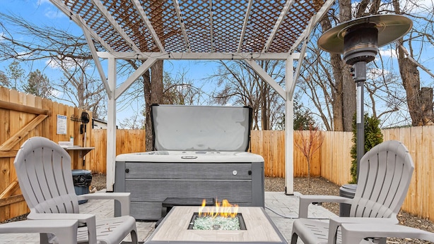 A patio with a fire pit, two Adirondack chairs, and a covered seating area with a pergola. - The *Minimalist's Escape* near Greenbelt & Winery with HOT TUB! (Garden City)