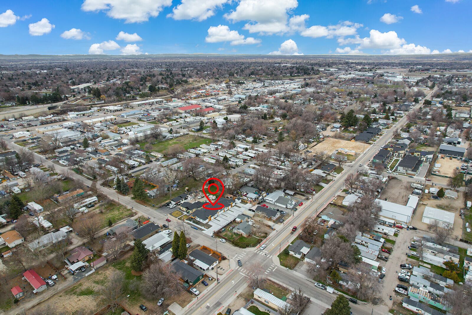 Une vue aérienne d’un quartier résidentiel avec des maisons, des rues et un grand espace ouvert.