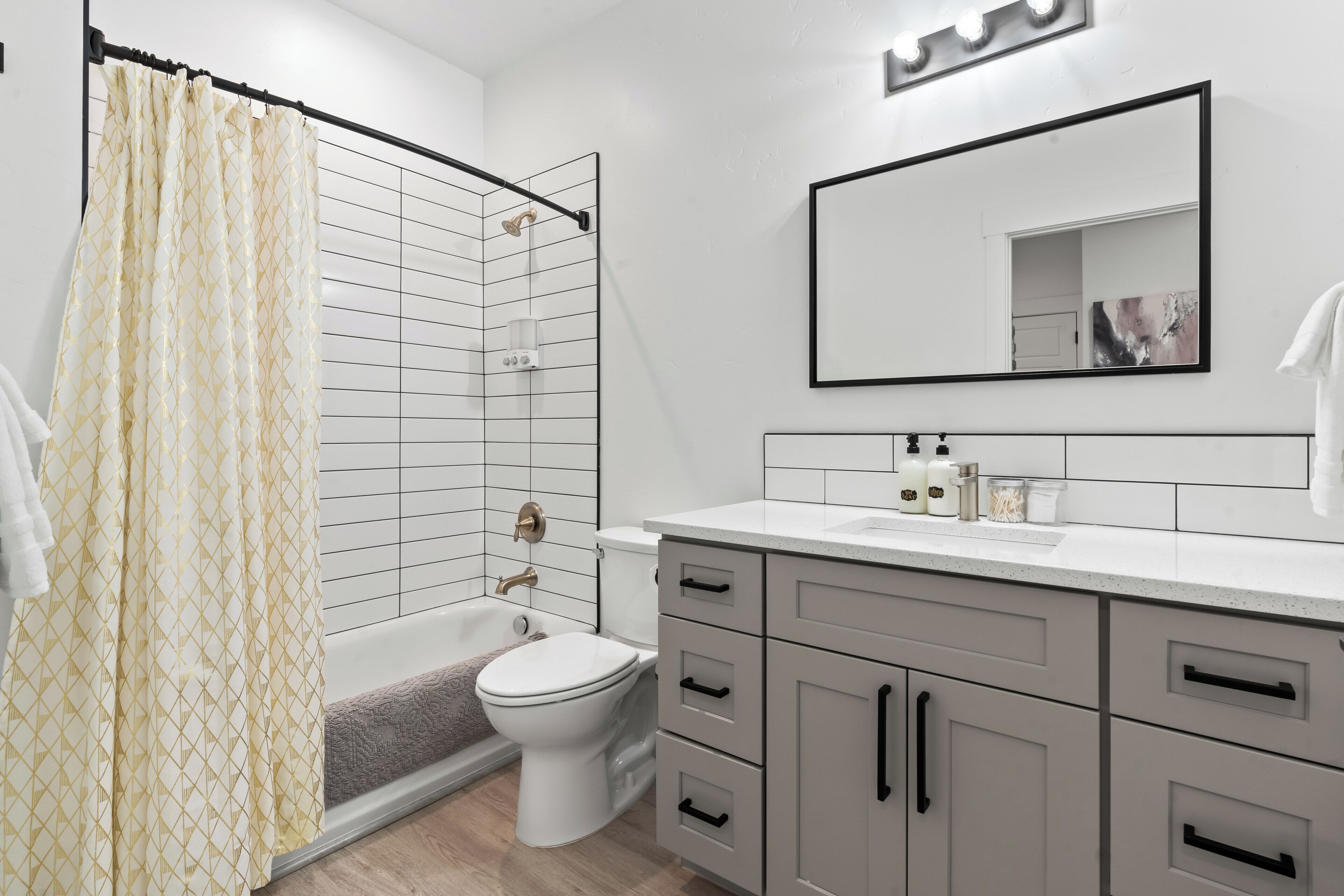 Une salle de bain moderne équipée d’une douche, de toilettes et d’un meuble-lavabo.
