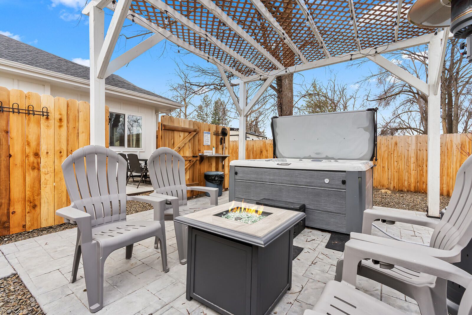 Une terrasse extérieure équipée d’un barbecue, de chaises et d’une pergola.