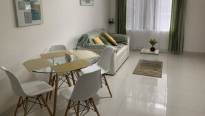 Una sala de estar moderna con una mesa de comedor, sillas, un sofá y una mesita de centro.