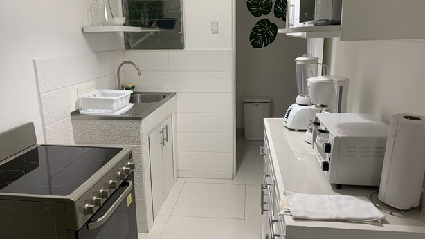 Una cocina moderna con estufa, lavamanos y electrodomésticos de encimera, como licuadora y tostadora.